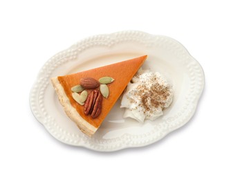 Photo of Piece of tasty homemade pumpkin pie with whipped cream, seeds and nuts isolated on white, top view