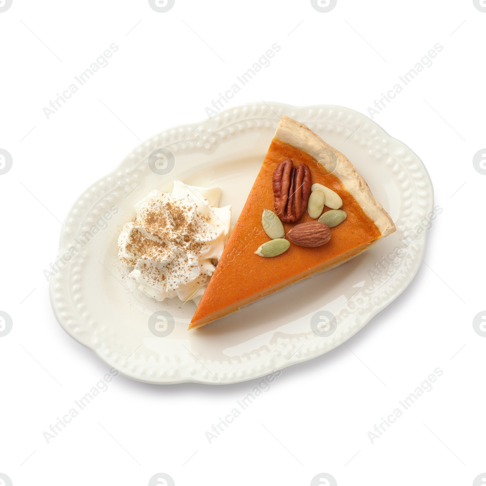 Photo of Piece of tasty homemade pumpkin pie with whipped cream, seeds and nuts isolated on white, top view