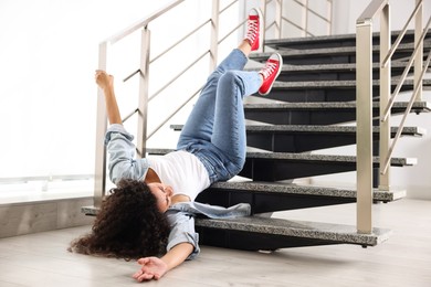 Photo of Injured woman on stairs in building after fall. Dangerous accident