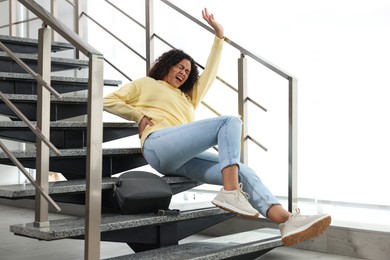 Photo of Injured woman on stairs in building after fall. Dangerous accident