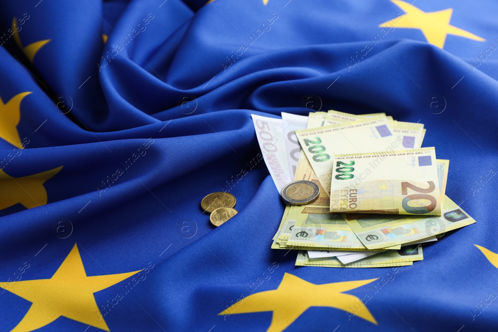 Photo of Euro banknotes and coins on European Union flag