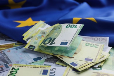 Photo of Euro banknotes and European Union flag, closeup