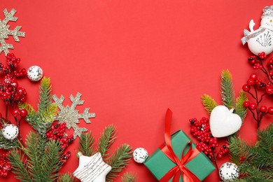 Photo of Flat lay composition with Christmas decor and gift box on red background. Space for text