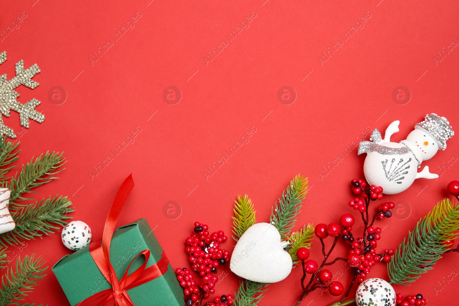 Photo of Flat lay composition with Christmas decor and gift box on red background. Space for text