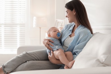 Photo of Mother with her sleeping baby on sofa at home