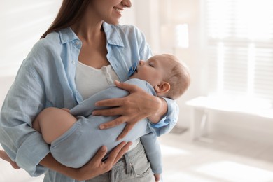 Photo of Mother holding her sleeping baby at home, closeup. Space for text