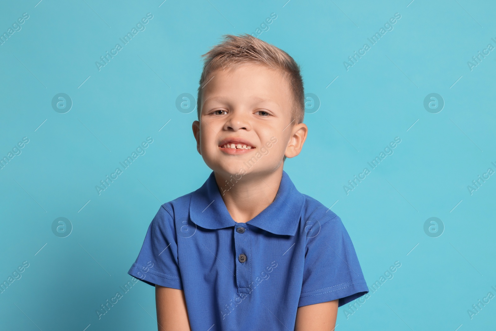 Photo of Portrait of little boy with stylish clothes on light blue background