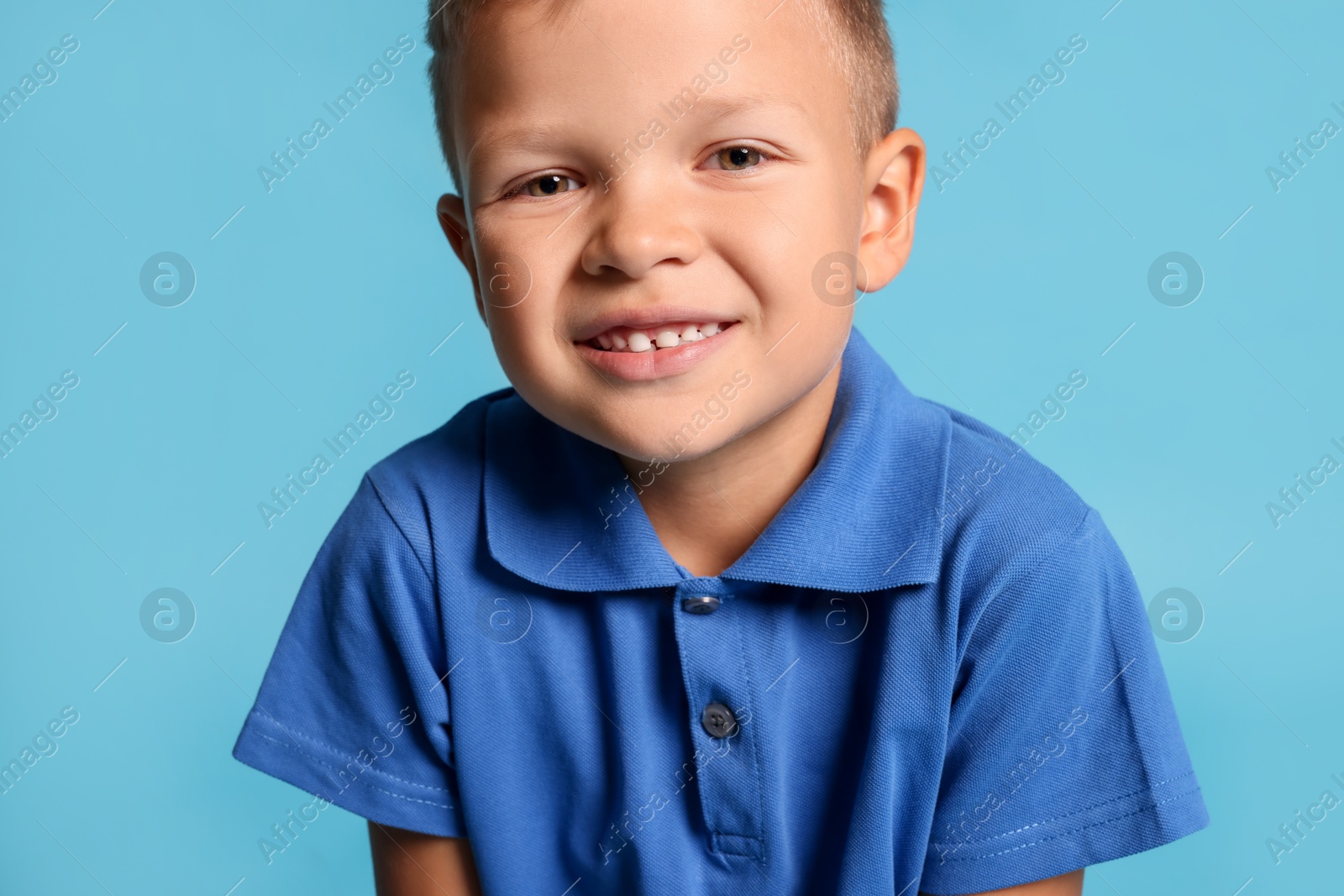 Photo of Portrait of little boy with stylish clothes on light blue background