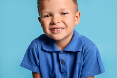 Portrait of little boy with stylish clothes on light blue background