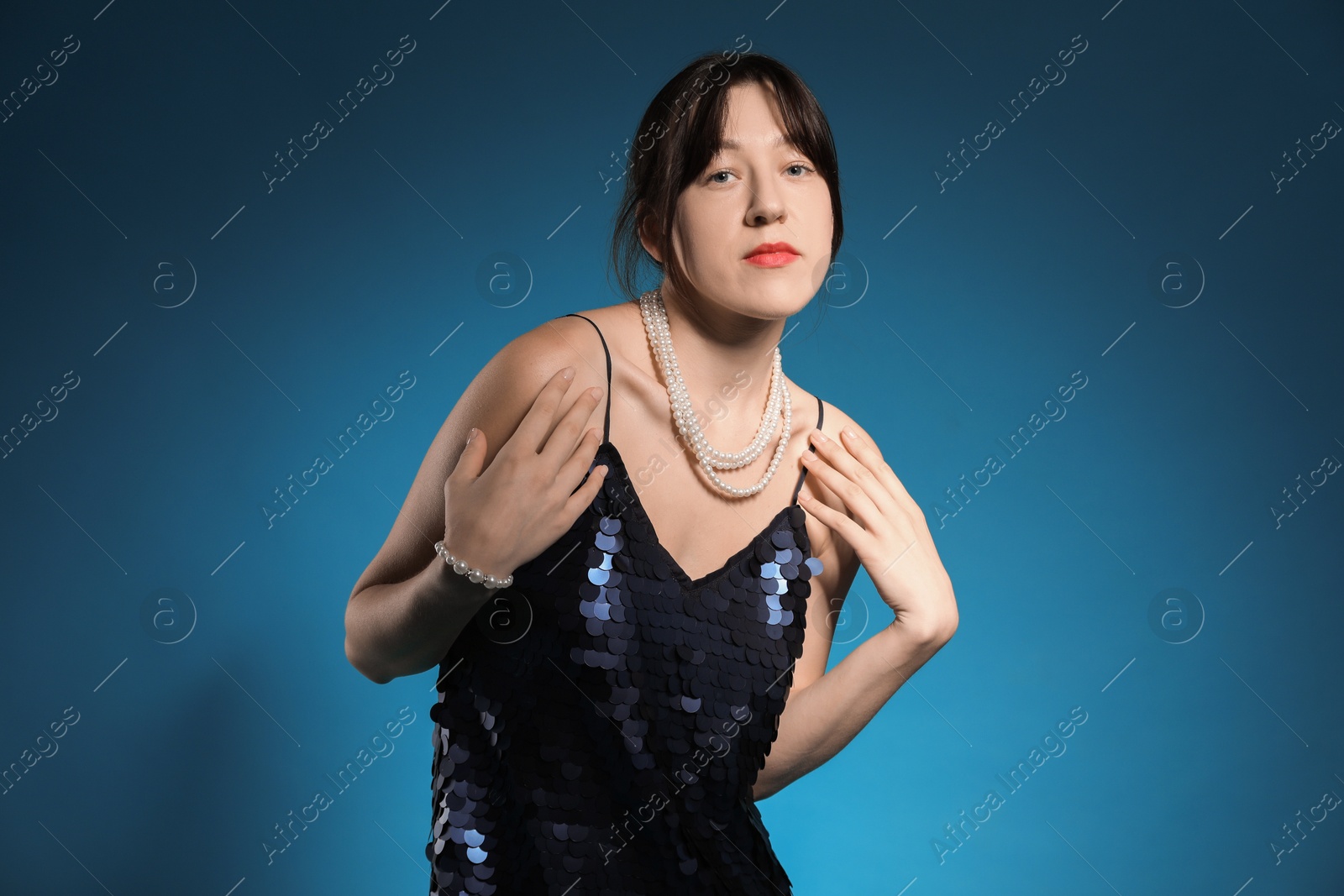 Photo of Beautiful young woman posing on blue background