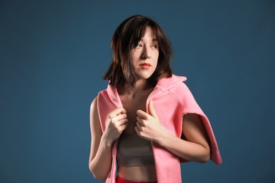 Photo of Beautiful young woman with pink shirt on blue background