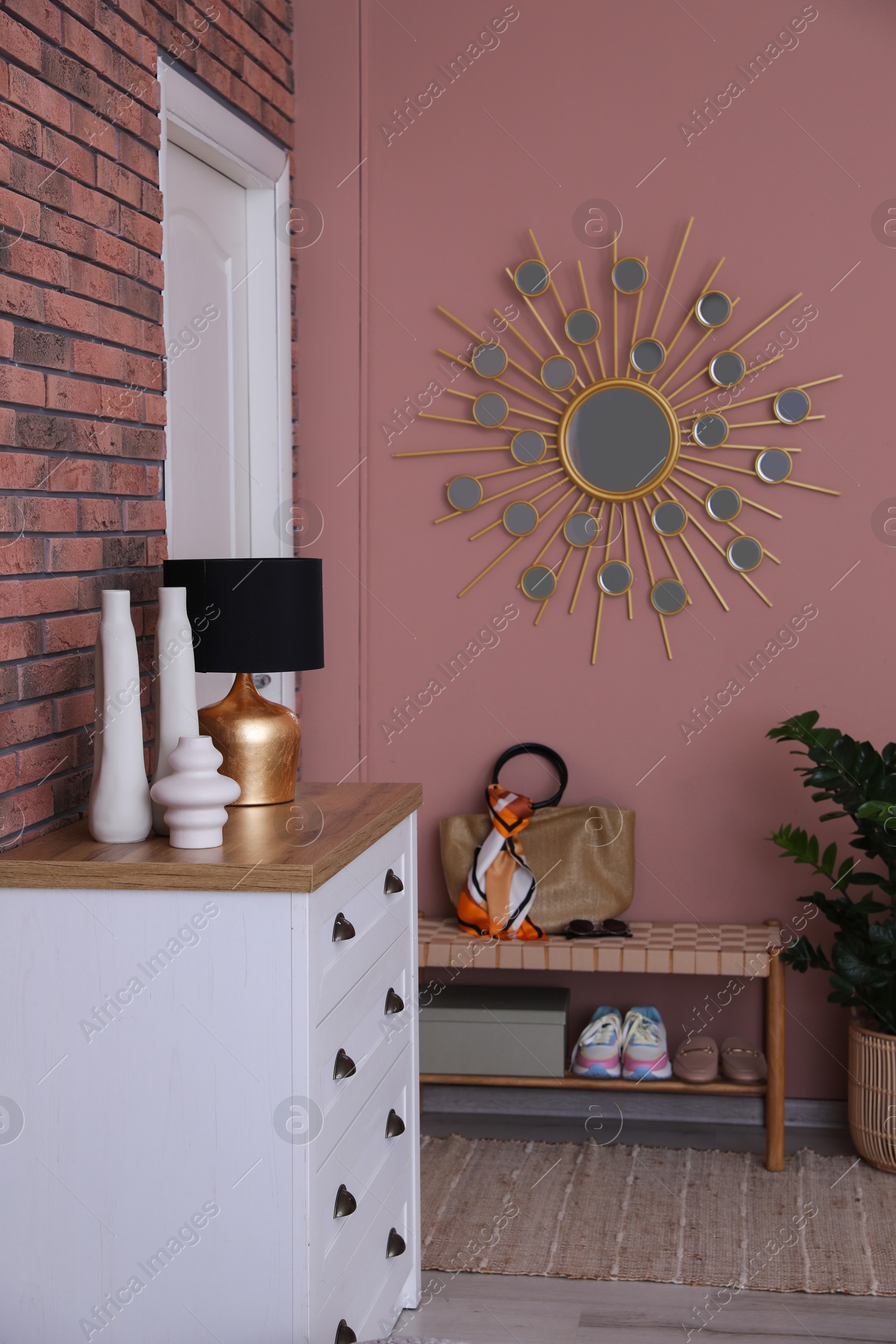 Photo of Stylish hallway interior with chest of drawers and bench