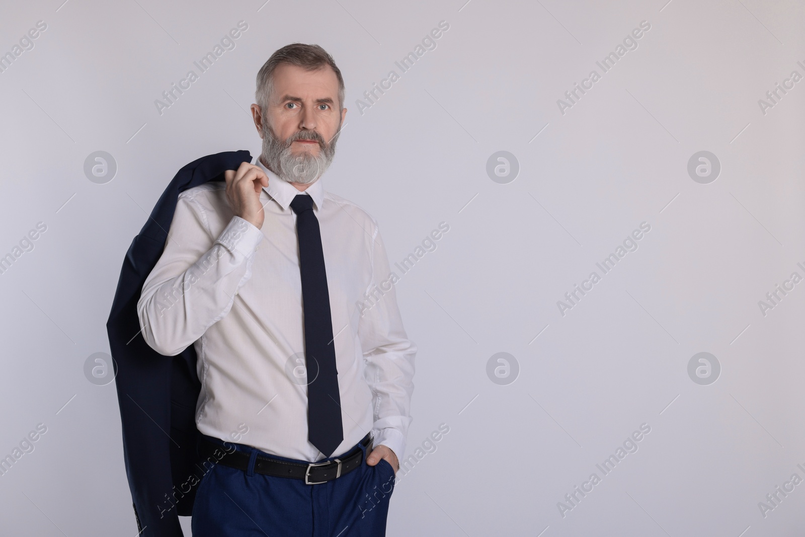 Photo of Portrait of senior man in suit on white background, space for text