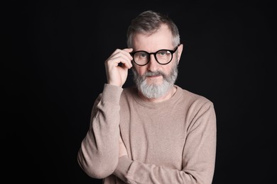 Photo of Senior man in glasses on black background