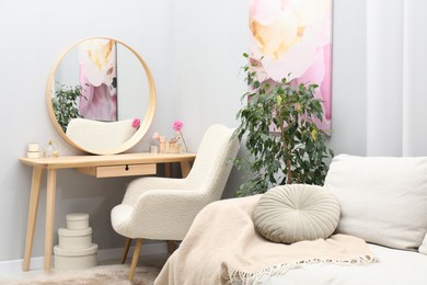 Photo of Mirror, dressing table, houseplant, sofa and armchair indoors. Interior design