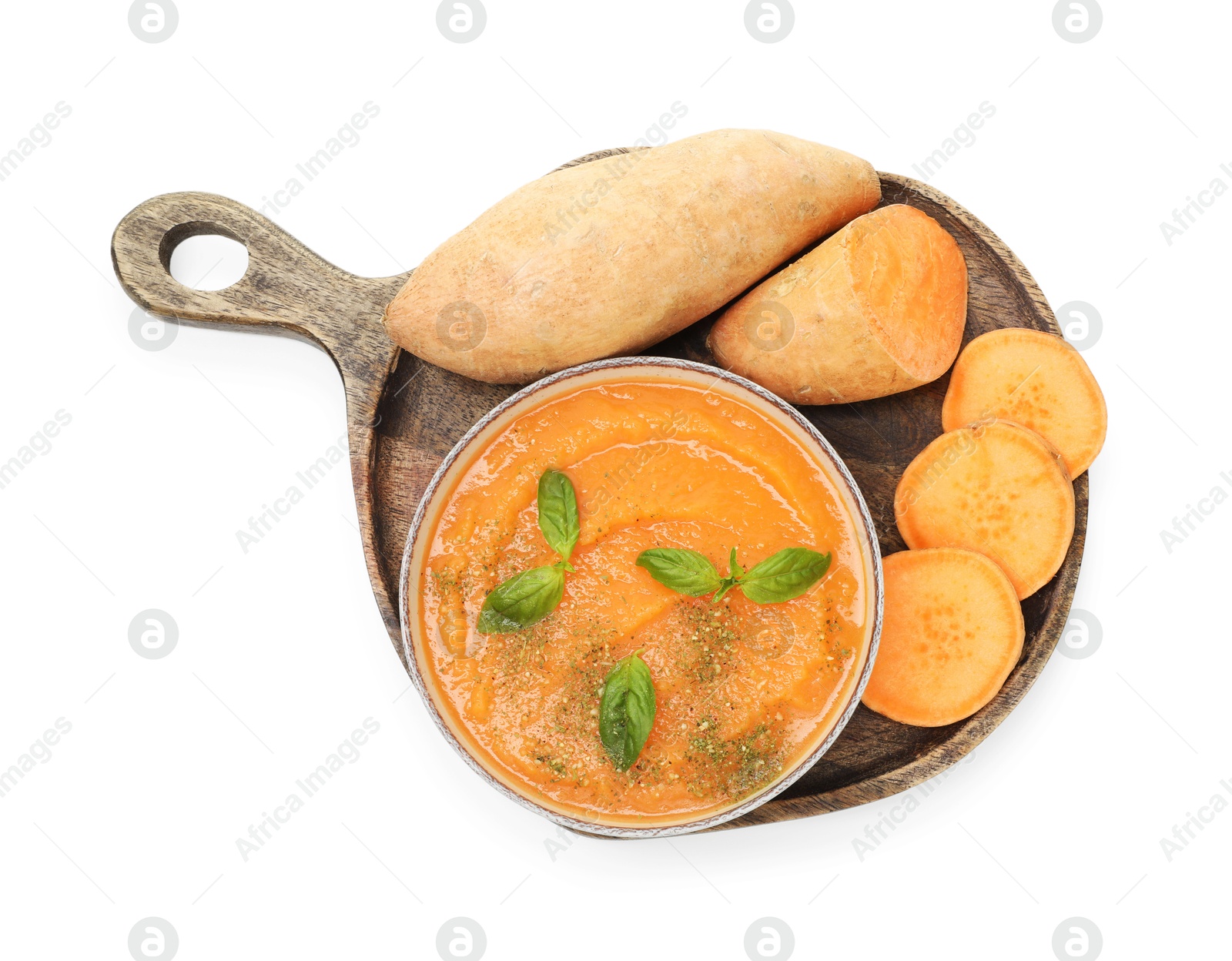 Photo of Delicious sweet potato soup with basil in bowl and fresh vegetables isolated on white, top view