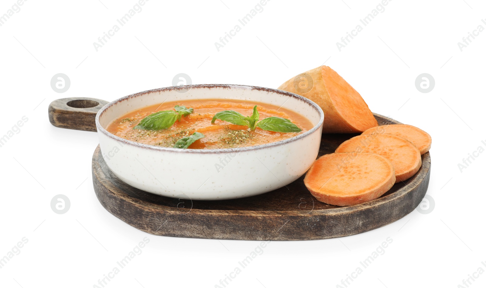 Photo of Delicious sweet potato soup with basil in bowl and fresh vegetables isolated on white