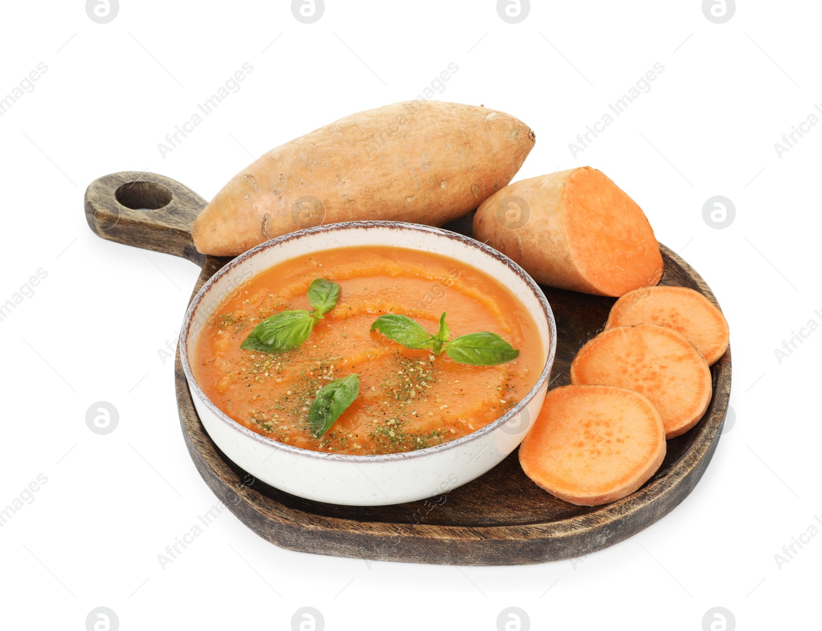 Photo of Delicious sweet potato soup with basil in bowl and fresh vegetables isolated on white