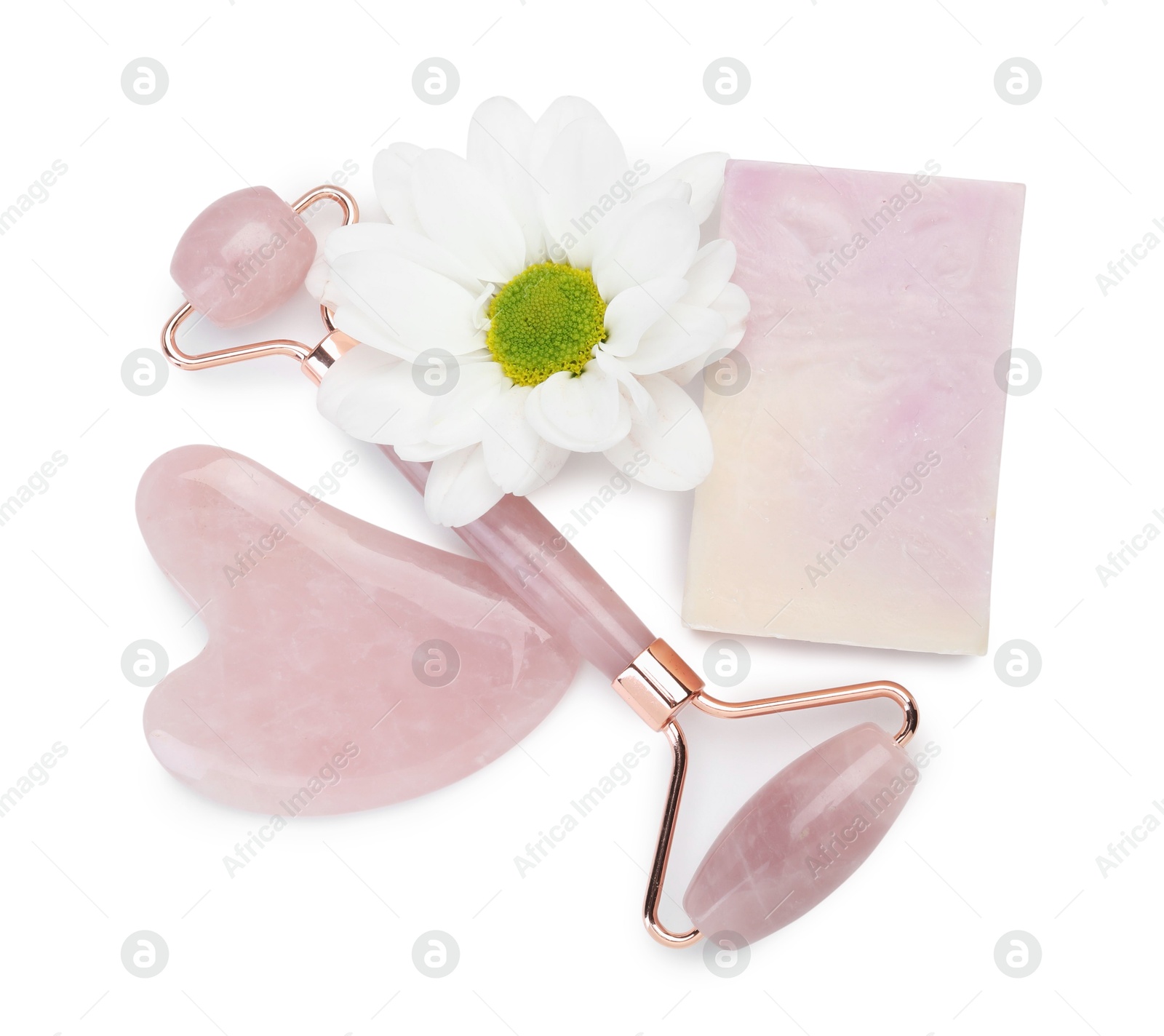 Photo of Face roller, soap, gua sha and flower isolated on white, top view