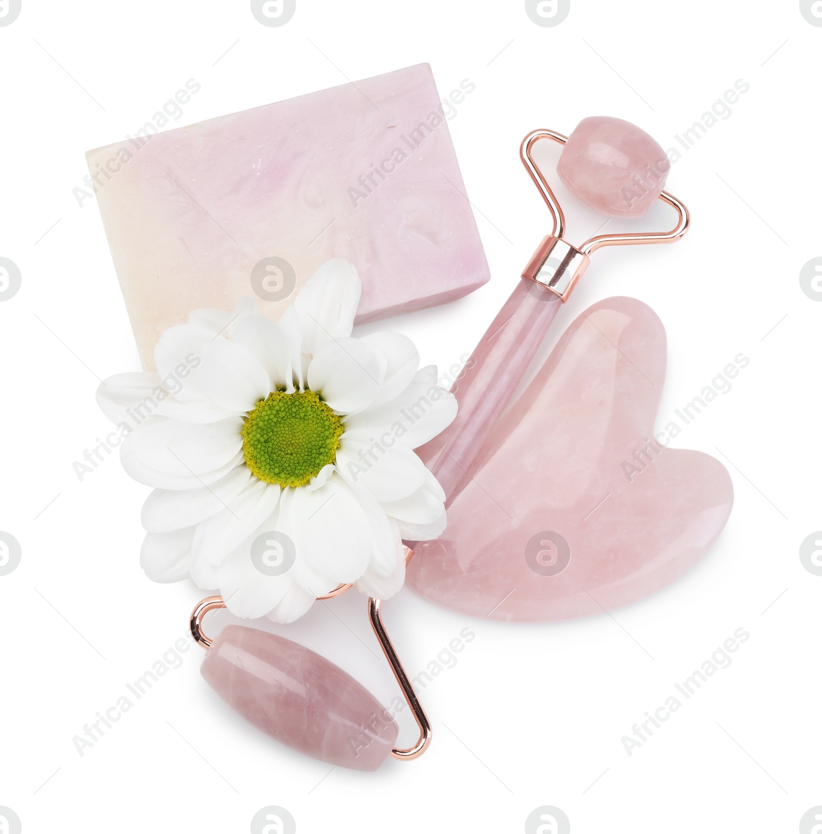 Photo of Face roller, soap, gua sha and flower isolated on white, top view