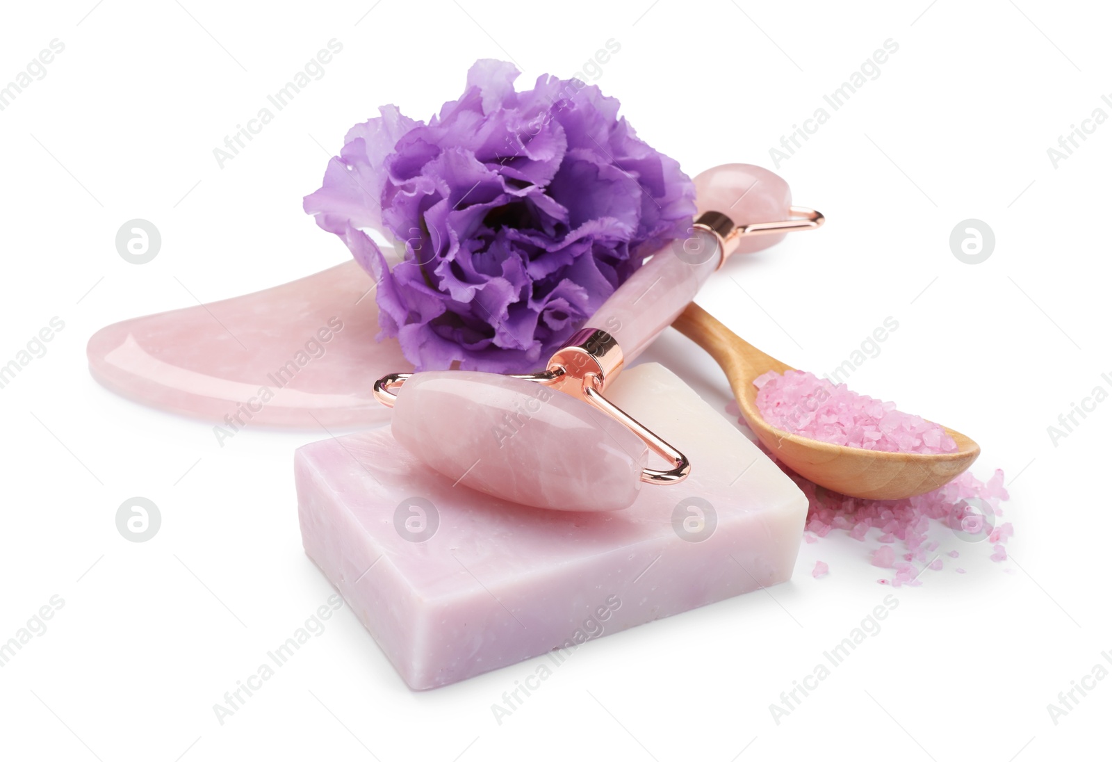 Photo of Face roller, soap, gua sha, sea salt and flower isolated on white