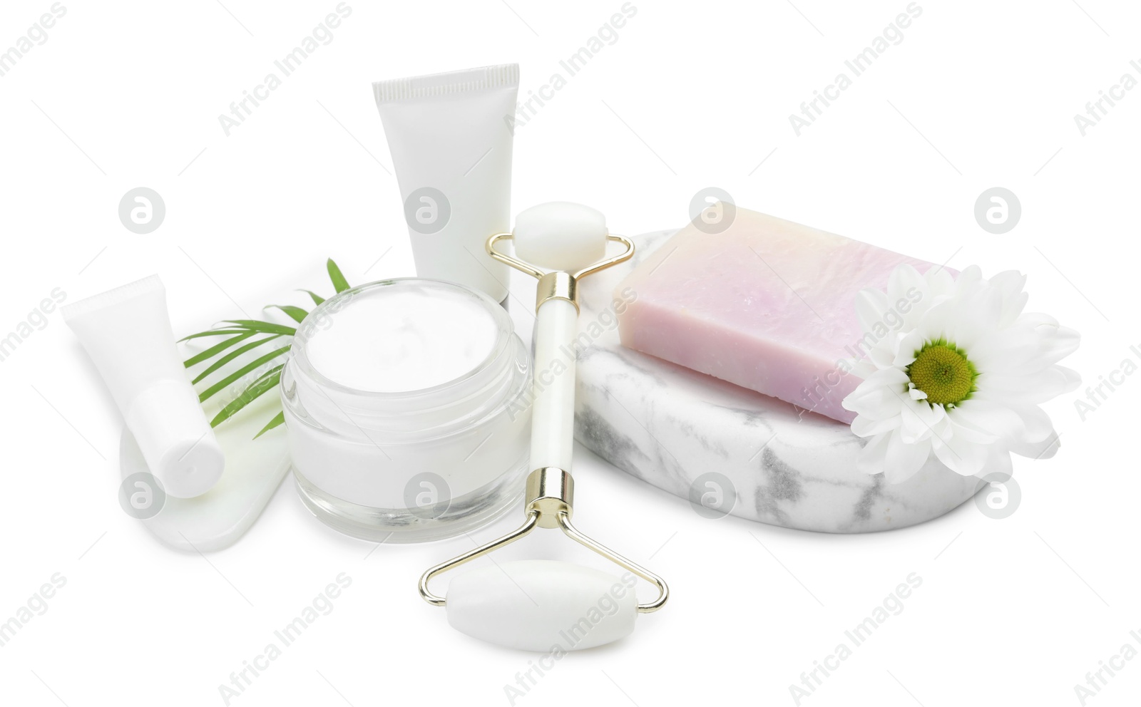 Photo of Face roller, cosmetic products, soap, gua sha and flower isolated on white