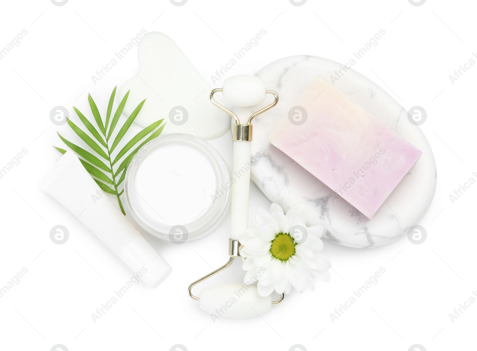 Photo of Face roller, cosmetic products, soap, gua sha and flower isolated on white, top view