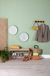 Photo of Stylish hallway interior with bench and folding screen