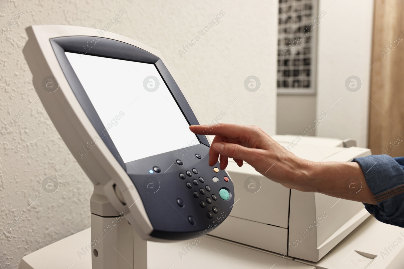 Photo of Woman using modern printer indoors, closeup. Printing house