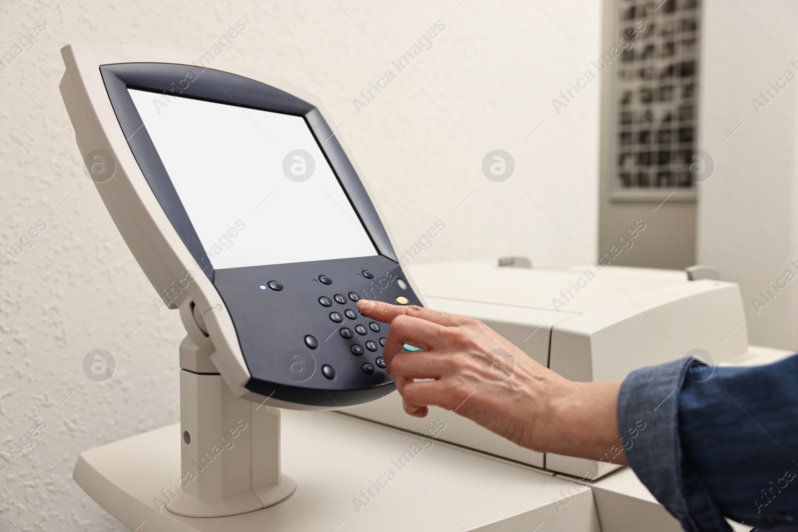 Photo of Woman using modern printer indoors, closeup. Printing house