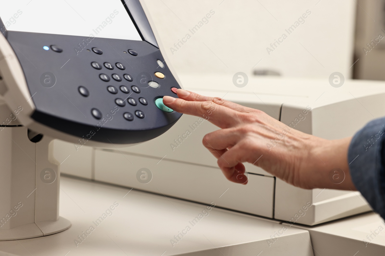 Photo of Woman using modern printer indoors, closeup. Printing house