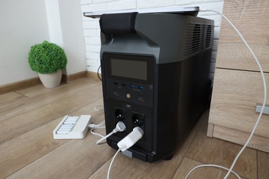 Photo of Modern portable power station, charging attached devices indoors