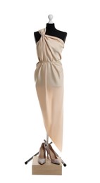 Draping beige fabric on female mannequin and shoes against white background