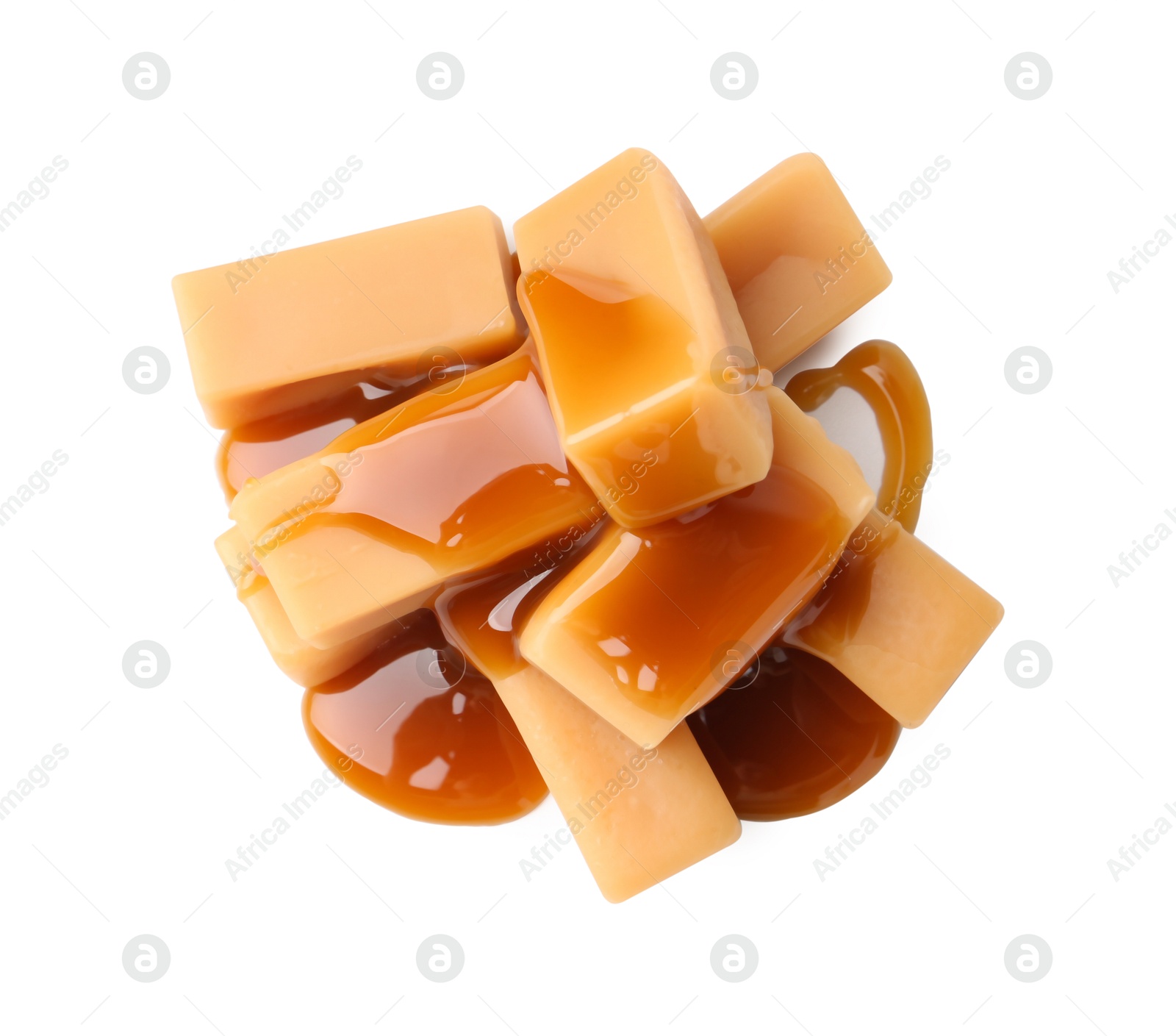 Photo of Tasty candies with caramel sauce isolated on white, top view