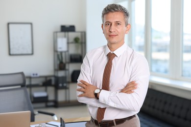 Photo of Portrait of middle aged man with crossed arms in office. Space for text