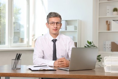 Portrait of middle aged man at table in office