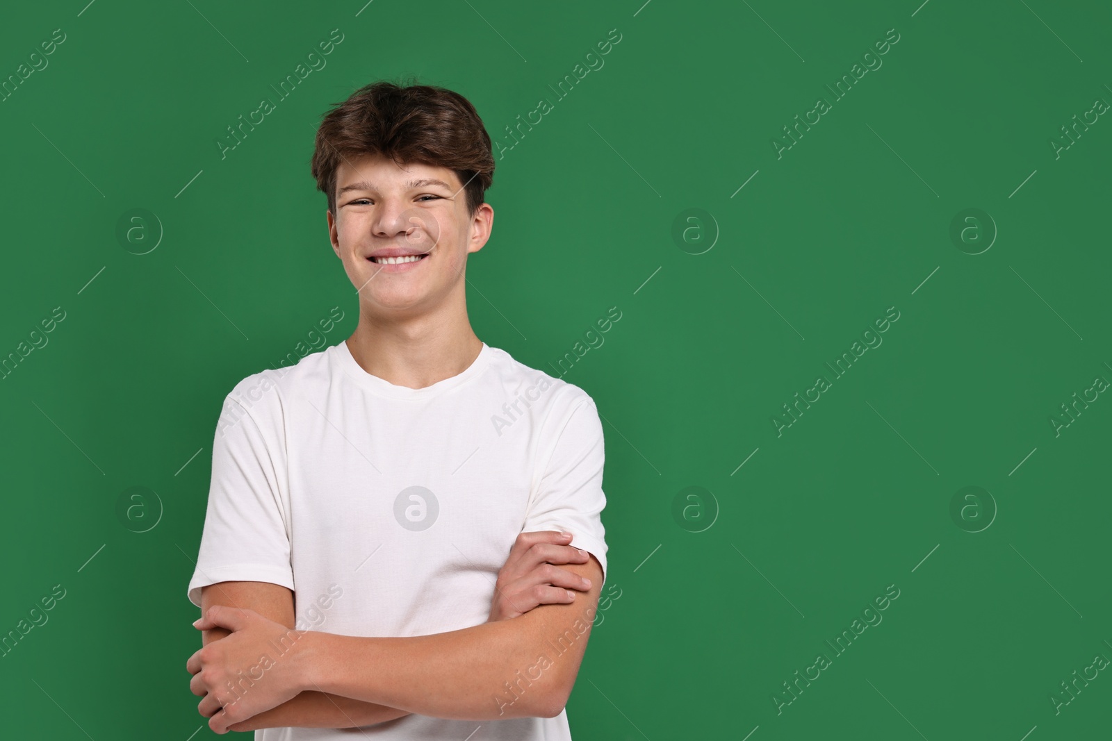 Photo of Portrait of teenage boy on green background, space for text