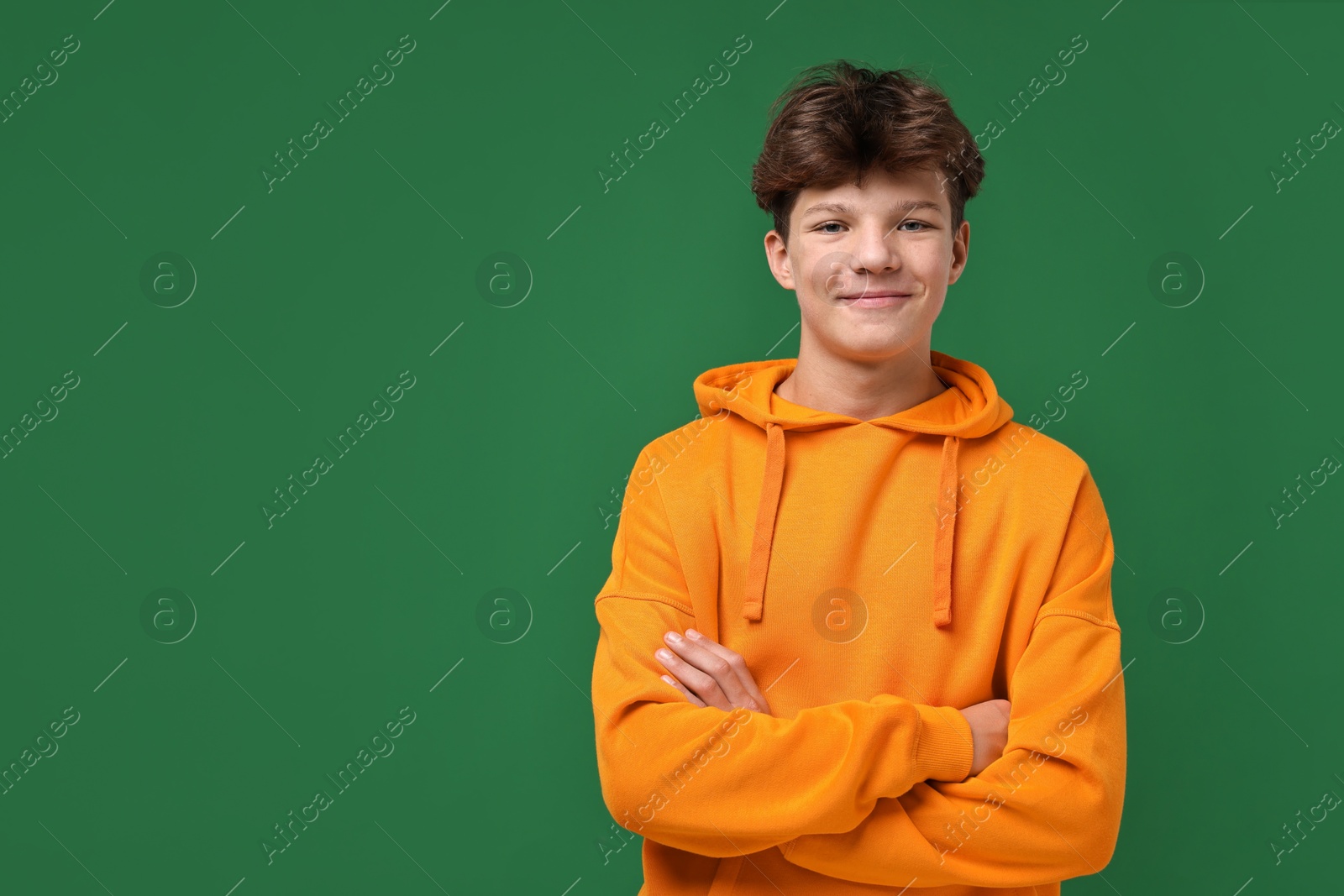 Photo of Portrait of happy teenage boy on green background, space for text