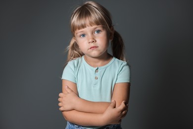 Photo of Orphanage concept. Sad little girl on grey background