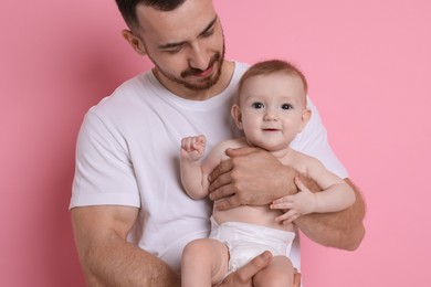 Photo of Father with his cute baby on pink background