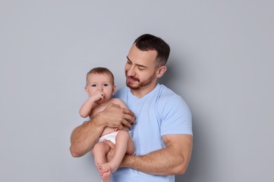 Photo of Father with his cute baby on grey background