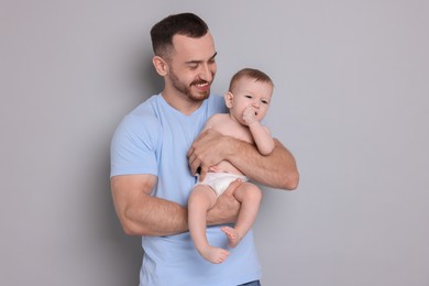 Photo of Father with his cute baby on grey background