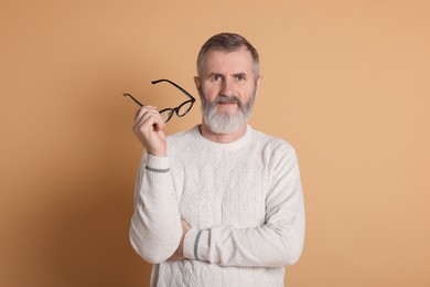 Photo of Portrait of senior man with glasses on beige background