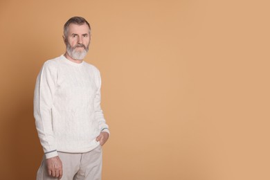 Photo of Portrait of senior man on beige background, space for text