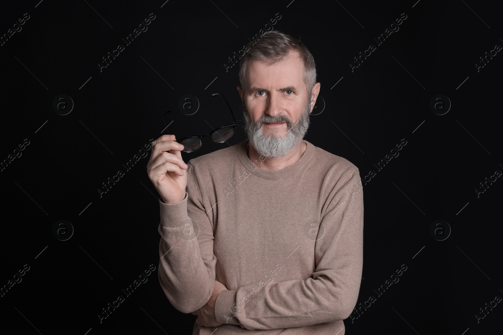 Photo of Senior man with glasses on black background