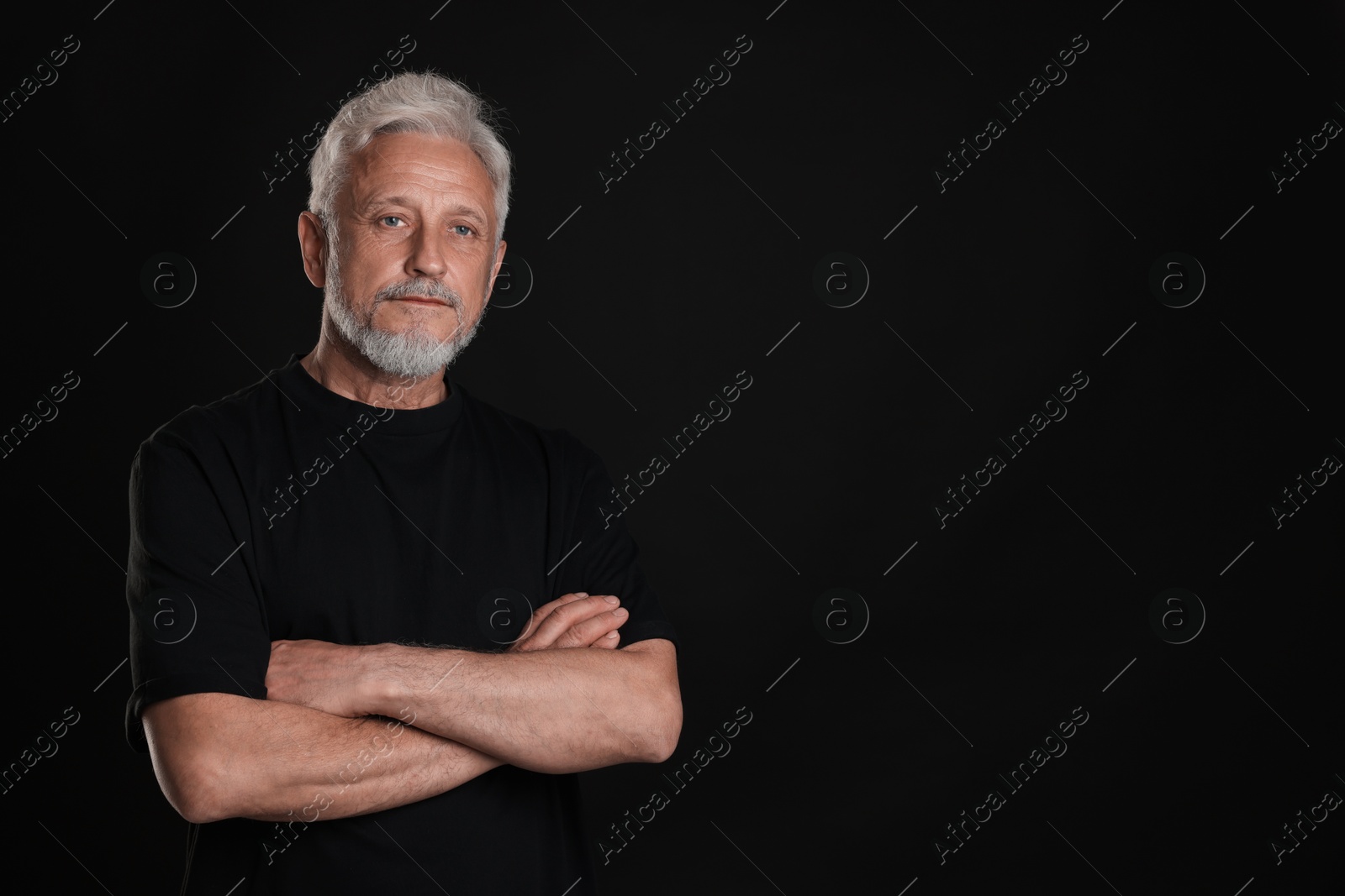 Photo of Portrait of senior man on black background, space for text