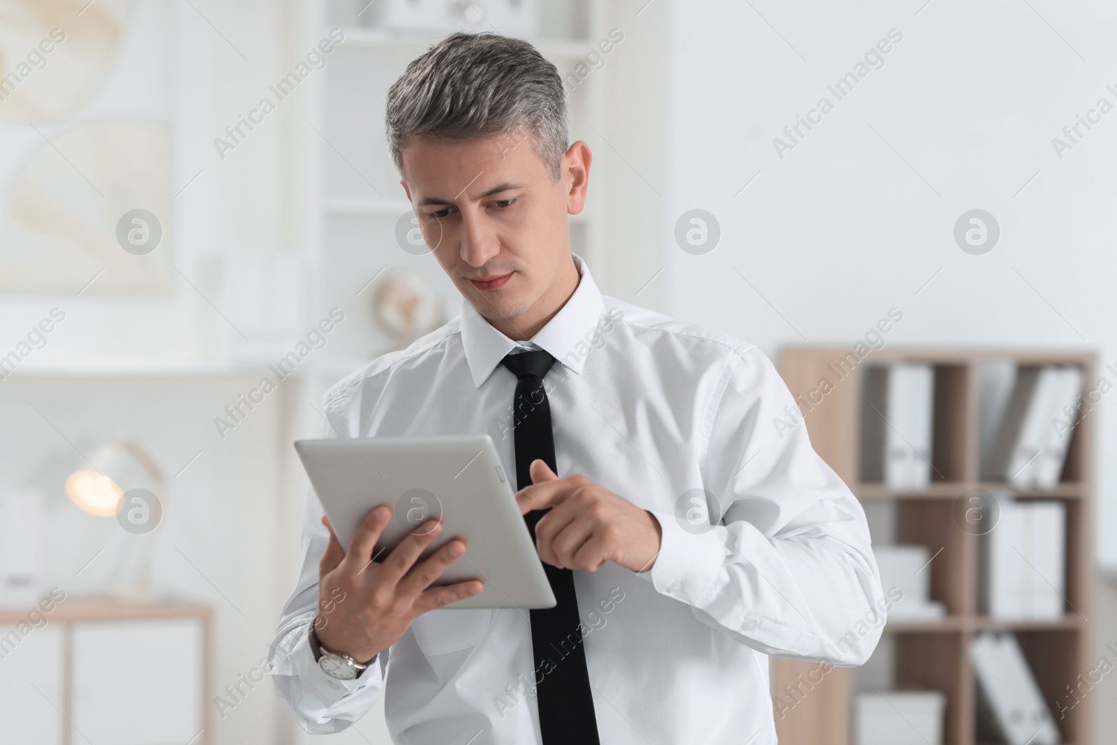 Photo of Portrait of businessman using tablet in office