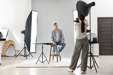 Photo of Photographer working with model in professional photo studio