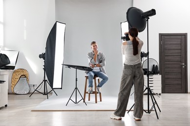 Photo of Photographer working with model in professional photo studio