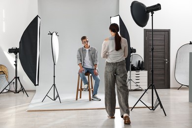 Photo of Photographer working with model in professional photo studio